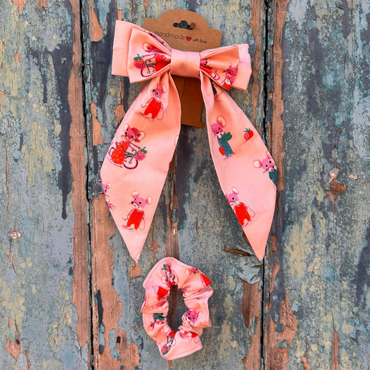 Pink hair bow and scrunchie set on a rustic wooden background