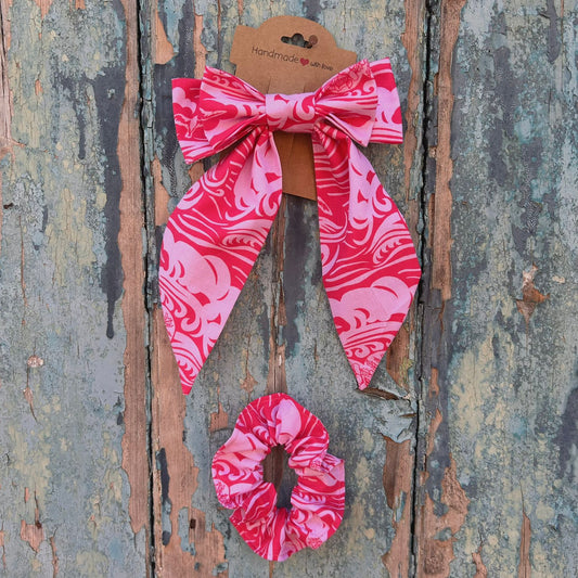 Pink hair bow and scrunchie set on a textured wooden background